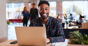 Man smiling with laptop | FourthRev